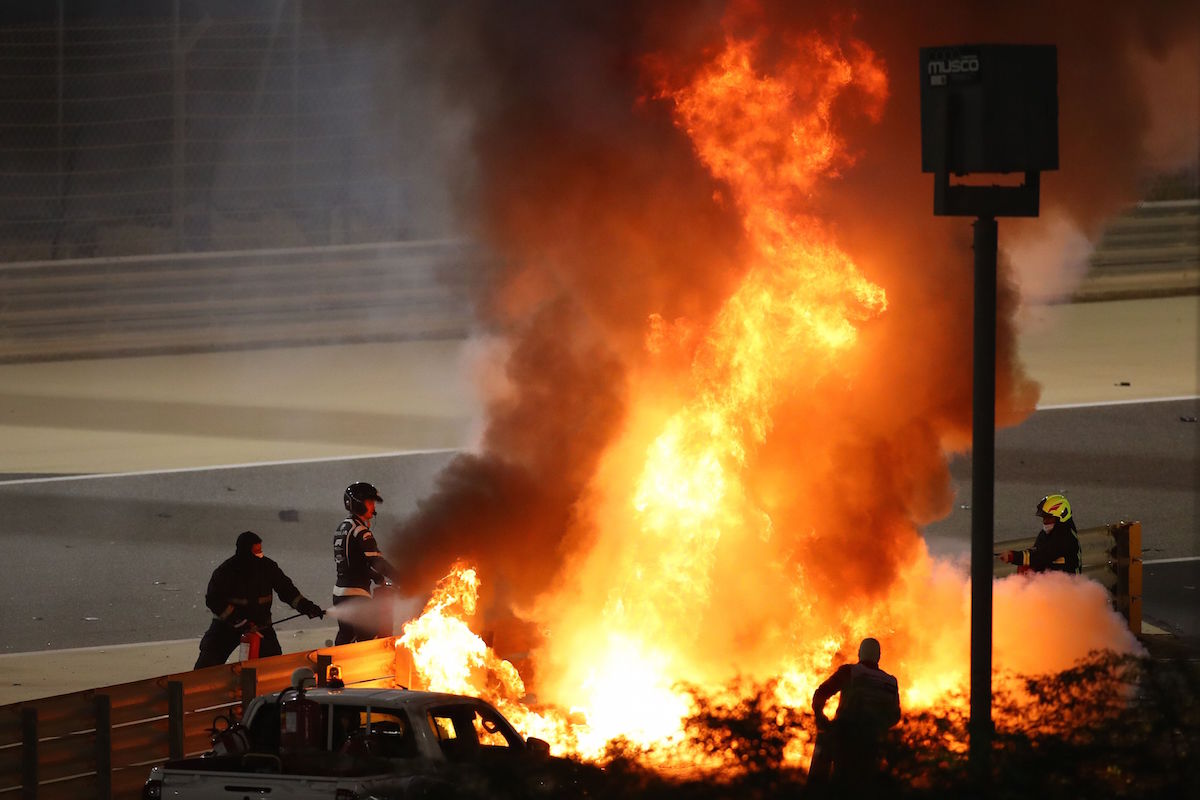 Fire marshals put out a fire on Haas F1's French driver Romain Grosjean's car during the Bahrain Formula One Grand Prix at the Bahrain International Circuit in the city of Sakhir on November 29, 2020. (Photo by Bryn Lennon / POOL / AFP)